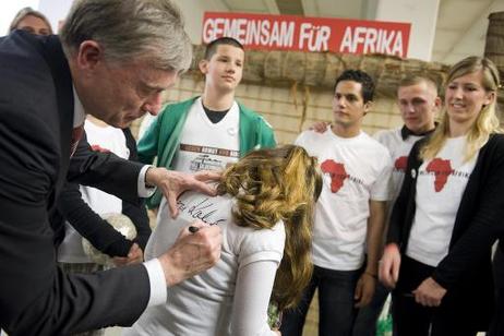 Bundespräsident Horst Köhler gibt einem Mädchen ein Autogramm auf ihr T-Shirt am Rande einer Podiumsdiskussion zur Fußballweltmeisterschaft im Oberstufenzentrum Logistik, Touristik, Immobilien, Steuern (OSZ Lotis).
